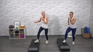 Two women doing a step cardio class