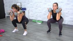 Two women doing squats with dumbbells