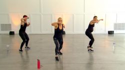 Two women wearing dark clothes doing a HIIT workout
