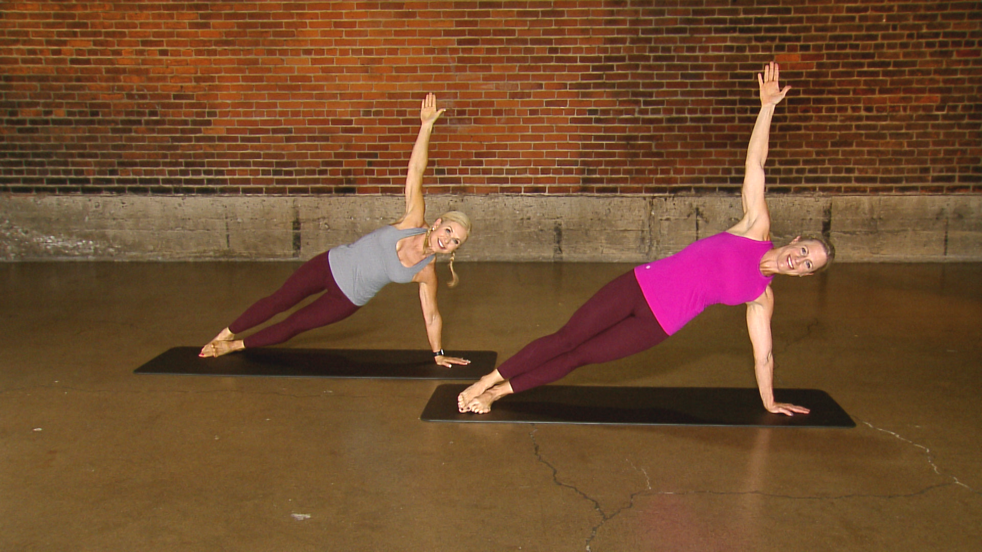 Two women doing side planks