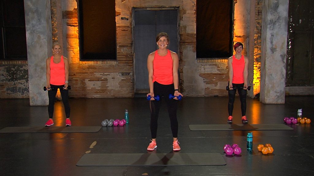 Three women in red tank tops working out with dumbbells