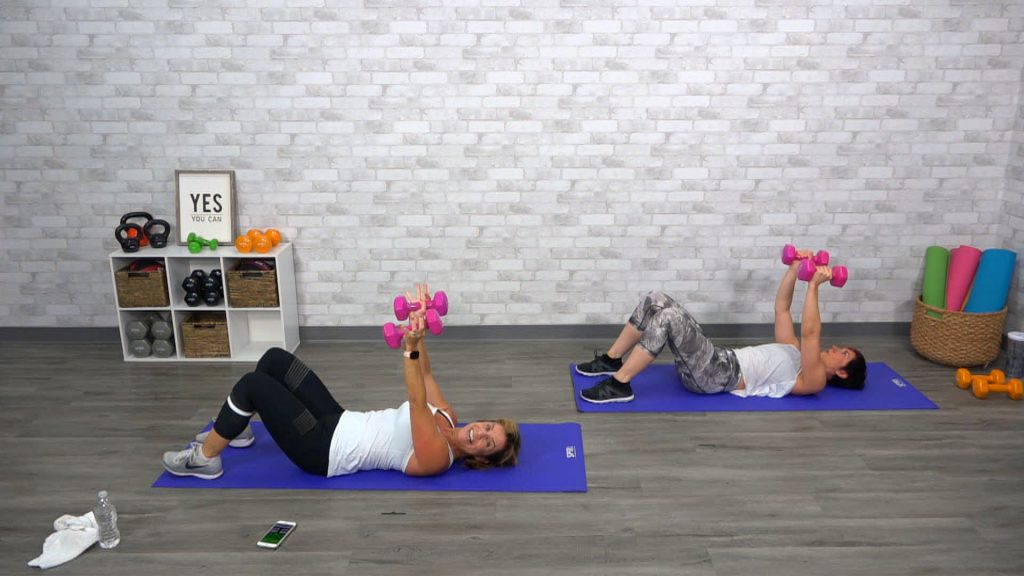 Two women doing a dumbbell workout on their backs