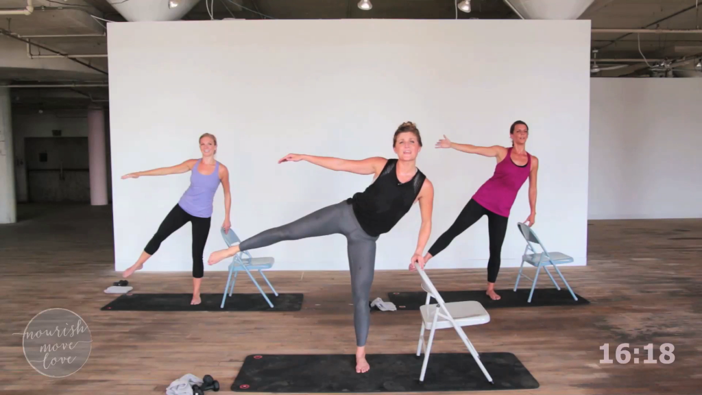 Three women doing a barre class with chairs