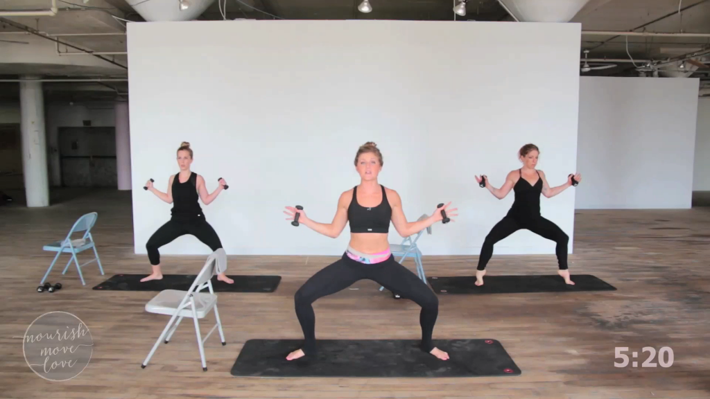 Screen shot from a video of a barre workout with three women in squat position