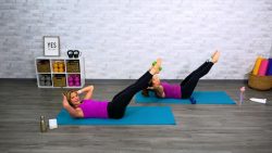Two women doing core workouts on mats