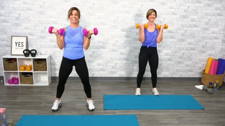 Two women in blue tank tops working out with dumbbells