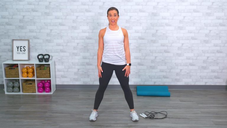 Woman standing before a workout with a jump rope on the ground