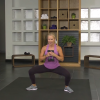 Woman doing a squat with a dumbbell