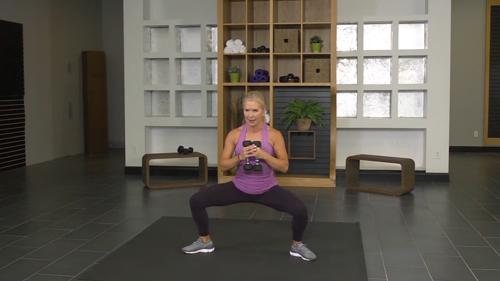 Woman doing a squat with a dumbbell