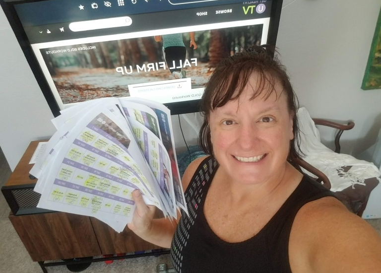 Woman holding up printed out workout calendar