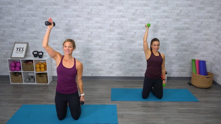 Two women working out on their knees with dumbbells