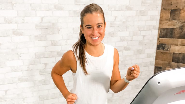 Woman wearing a white tank top on a treadmill
