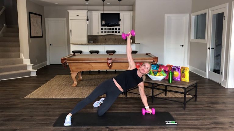 Women doing a side plank with dumbbells in a room