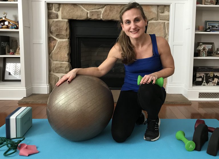 Woman with a stability ball and small green dumbbell