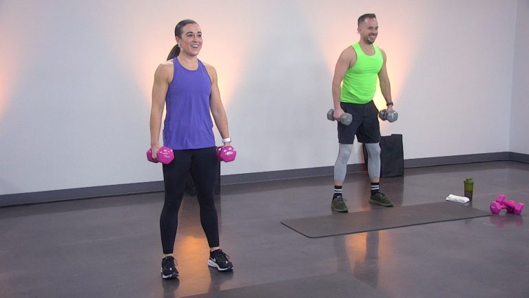 Two people standing with dumbbells by their sides