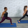 Two women doing yoga on blue mats