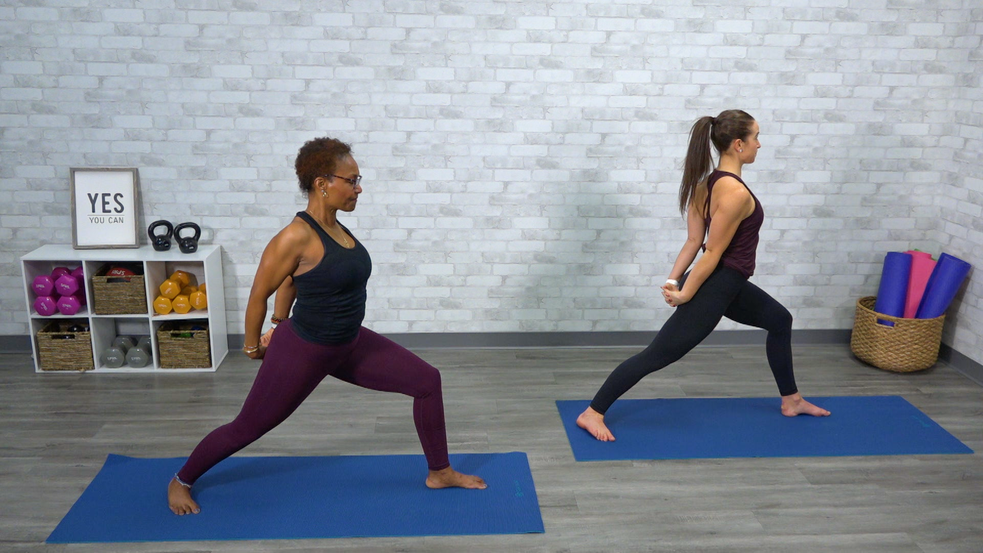 Two women doing yoga on blue mats