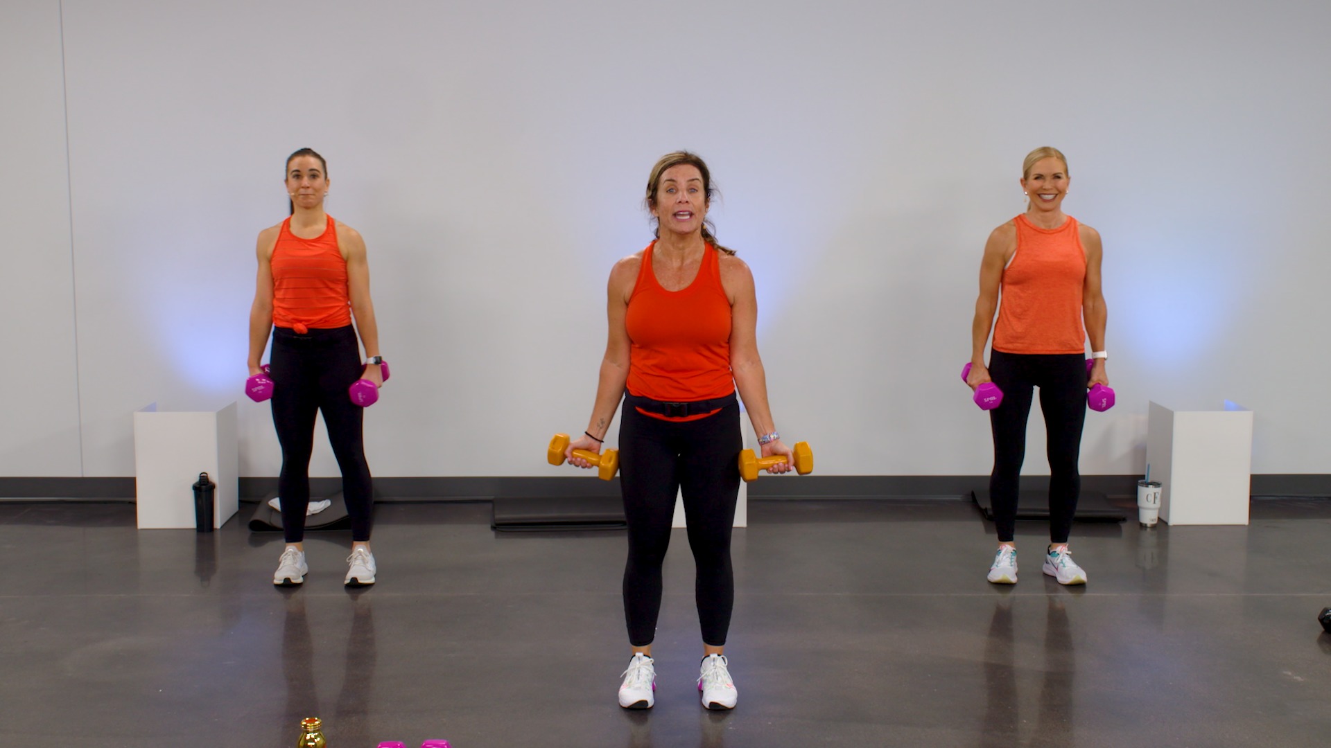 Three women working out with weights