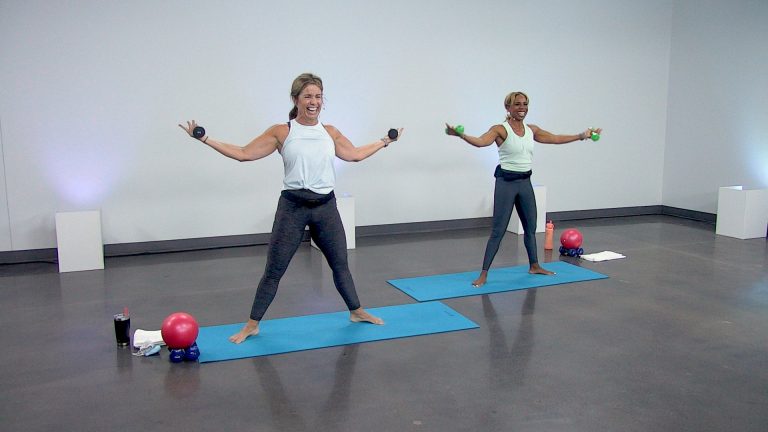 Two women doing a barre class with weights