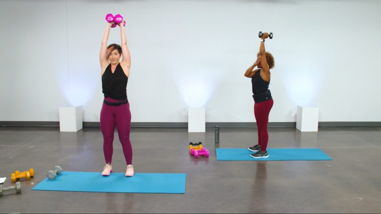 Two women working out with dumbbells overhead