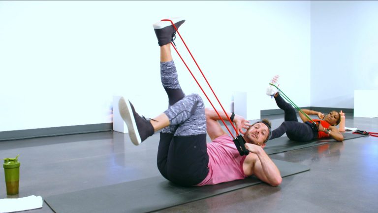 Two people working out on their backs with resistance bands