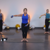 Three women doing a barre workout with weights