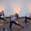 Three women working with dumbbells in a room with balloons