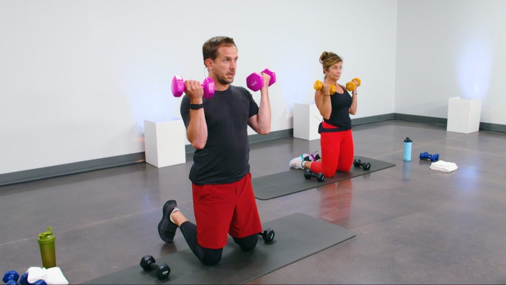 Two people doing bicep curls on their knees with dumbbells