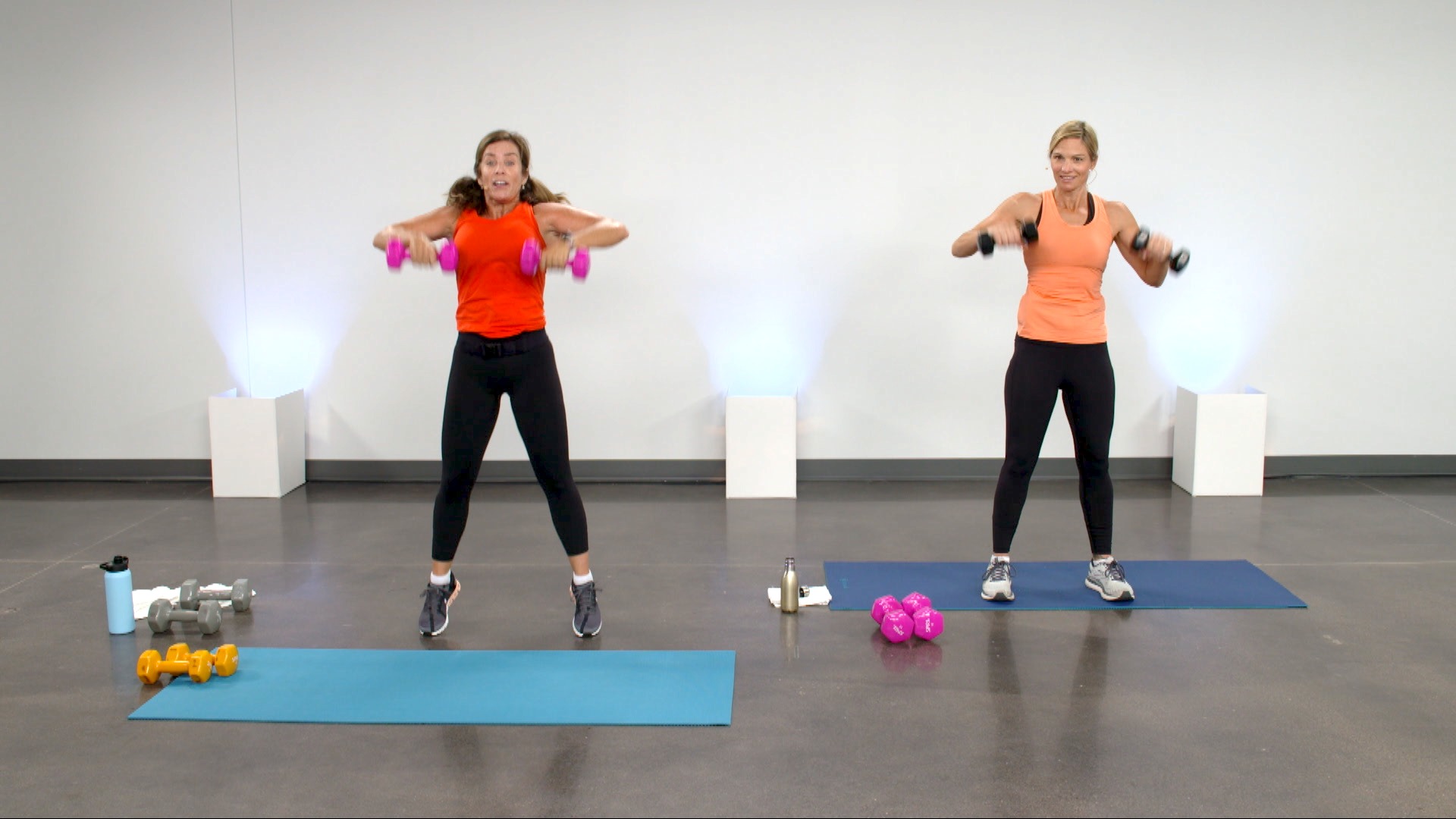 Two women doing an upper body workout with dumbbells