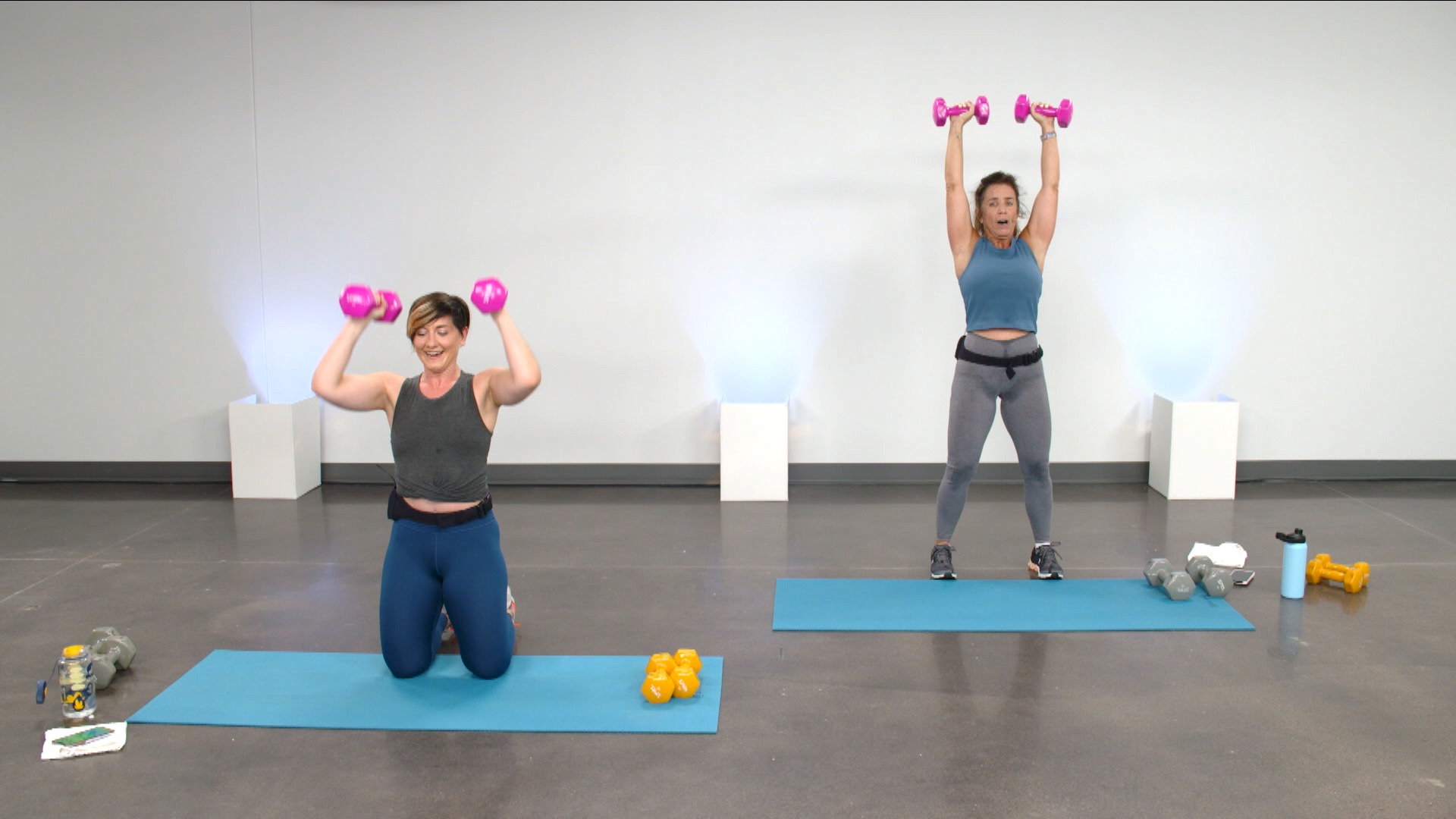 Two women working out with pink dumbbells