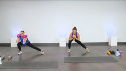 Two women doing lateral lunges with weights