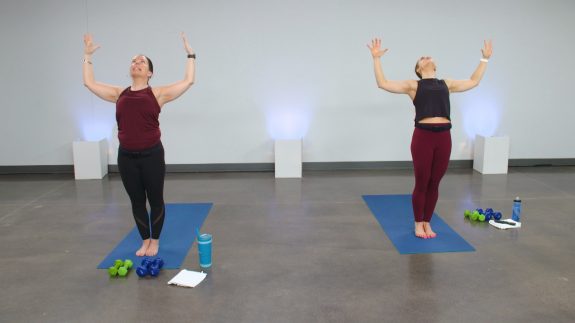 Two women doing yoga poses on blue exercise mats
