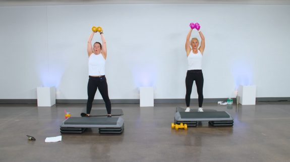 Two women holding dumbbells overhead