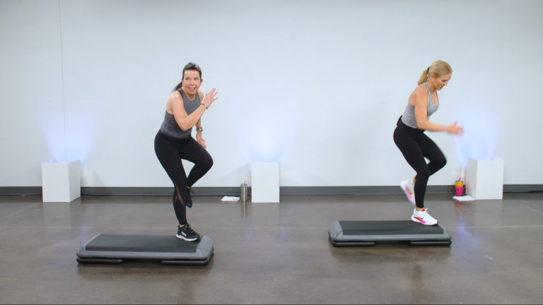 Two women doing a cardio step workout