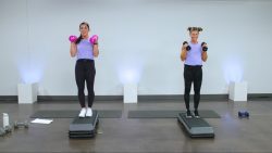 Two women working out with dumbbells on steps