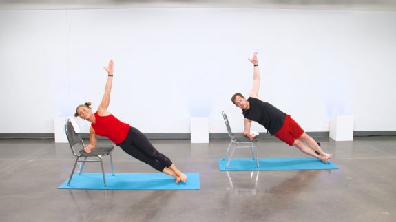 Two people doing side arm planks on chairs