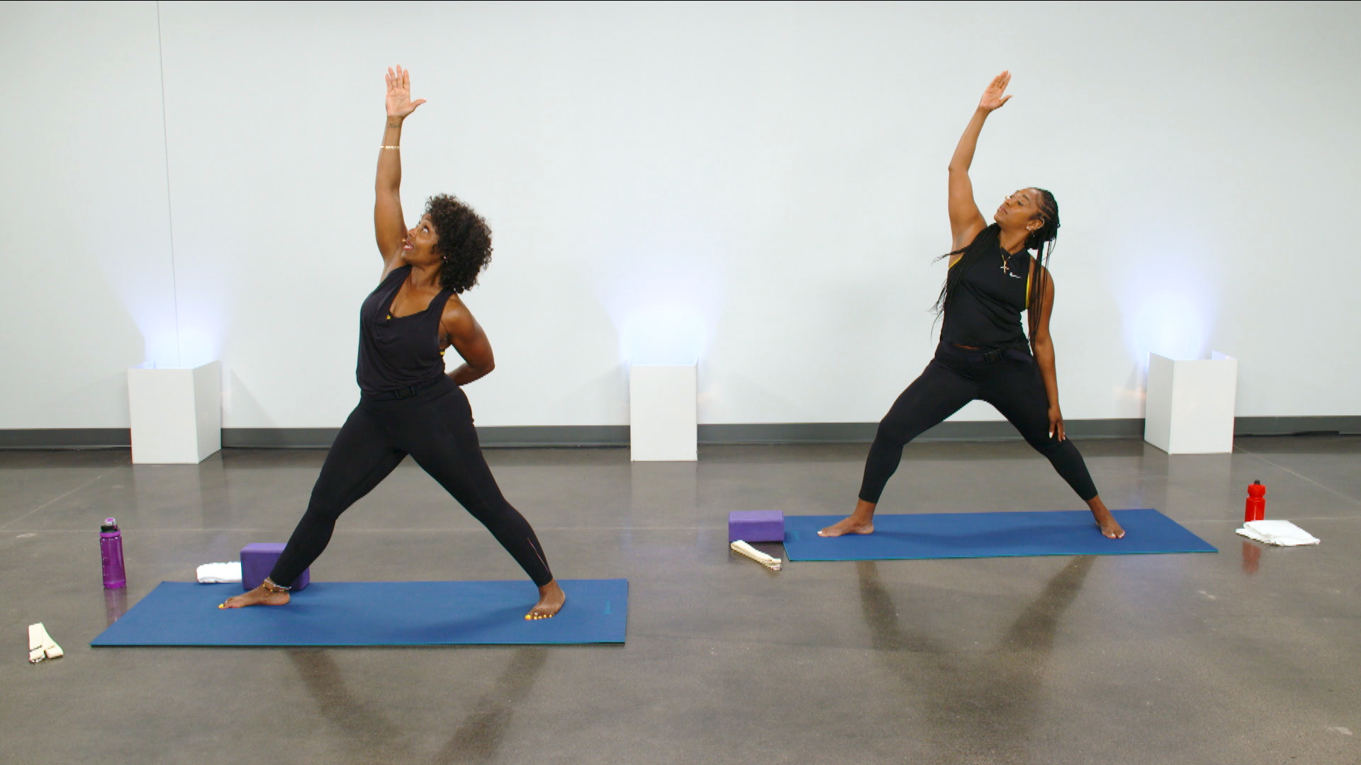 Two women doing a yoga pose with their arms up