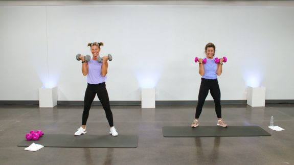 Two women in lavender tops working out with dumbbells