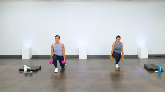 Two women doing lunges with dumbbells