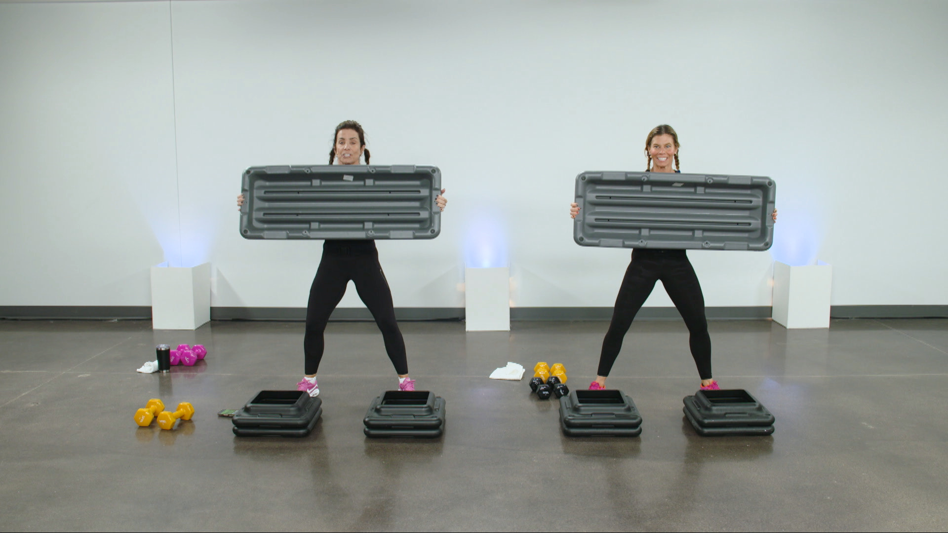Two women holding a workout step
