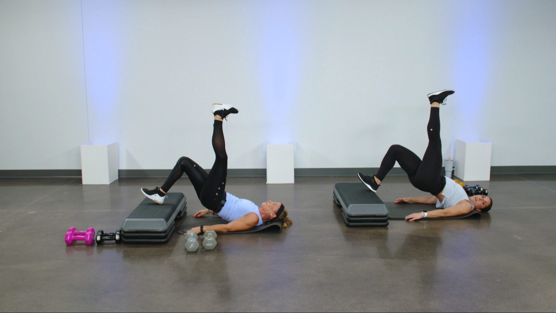 Two women doing leg raises on a step