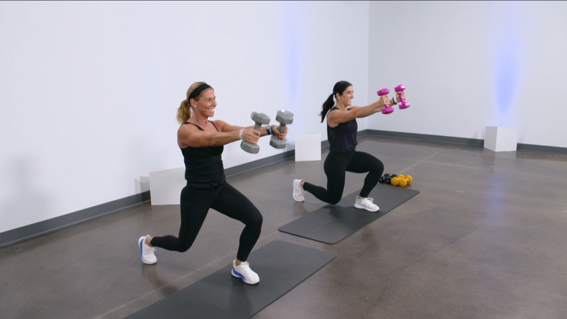 Two women doing lunges with dumbbells