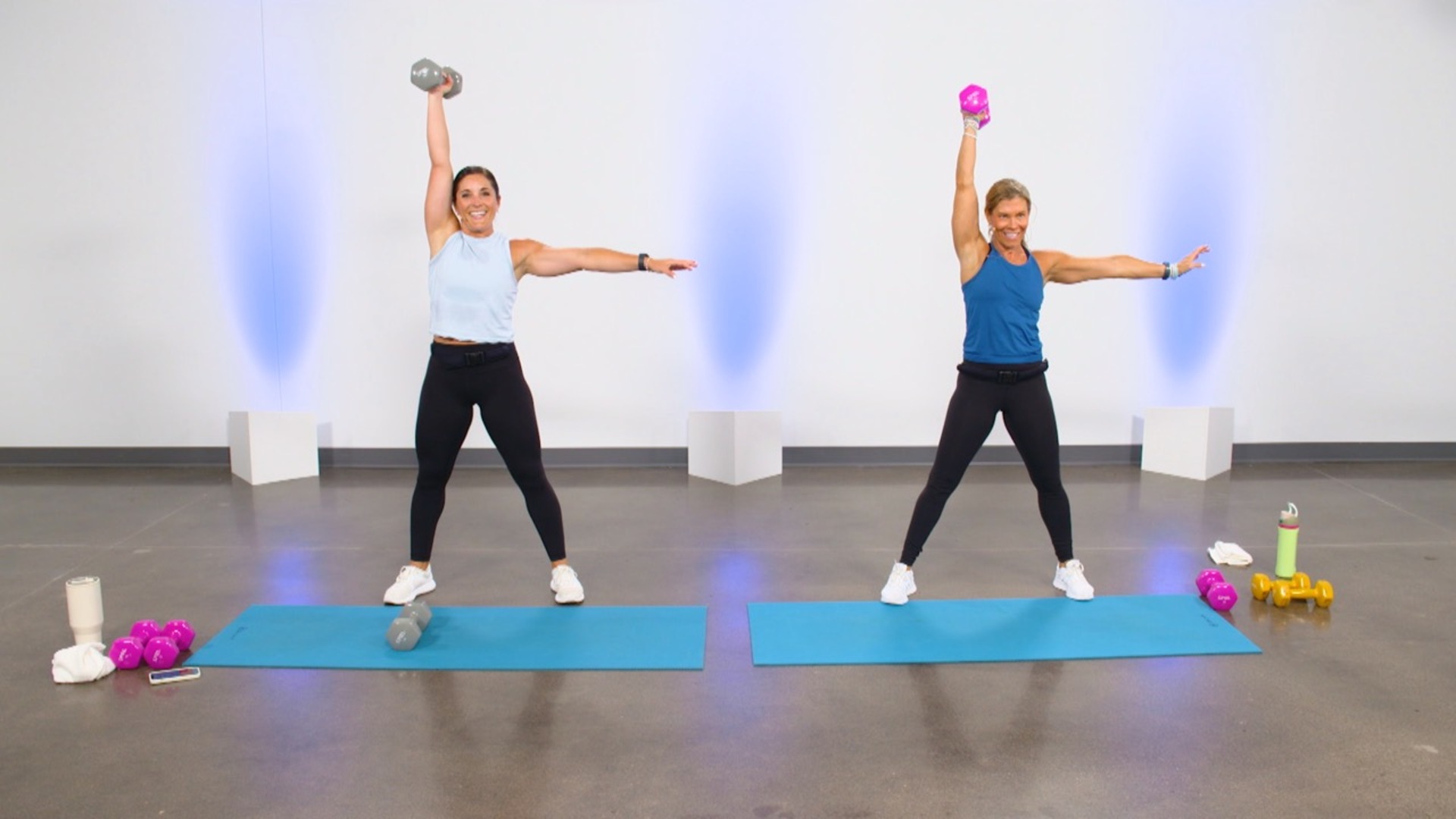 Two women doing single arm dumbbell presses