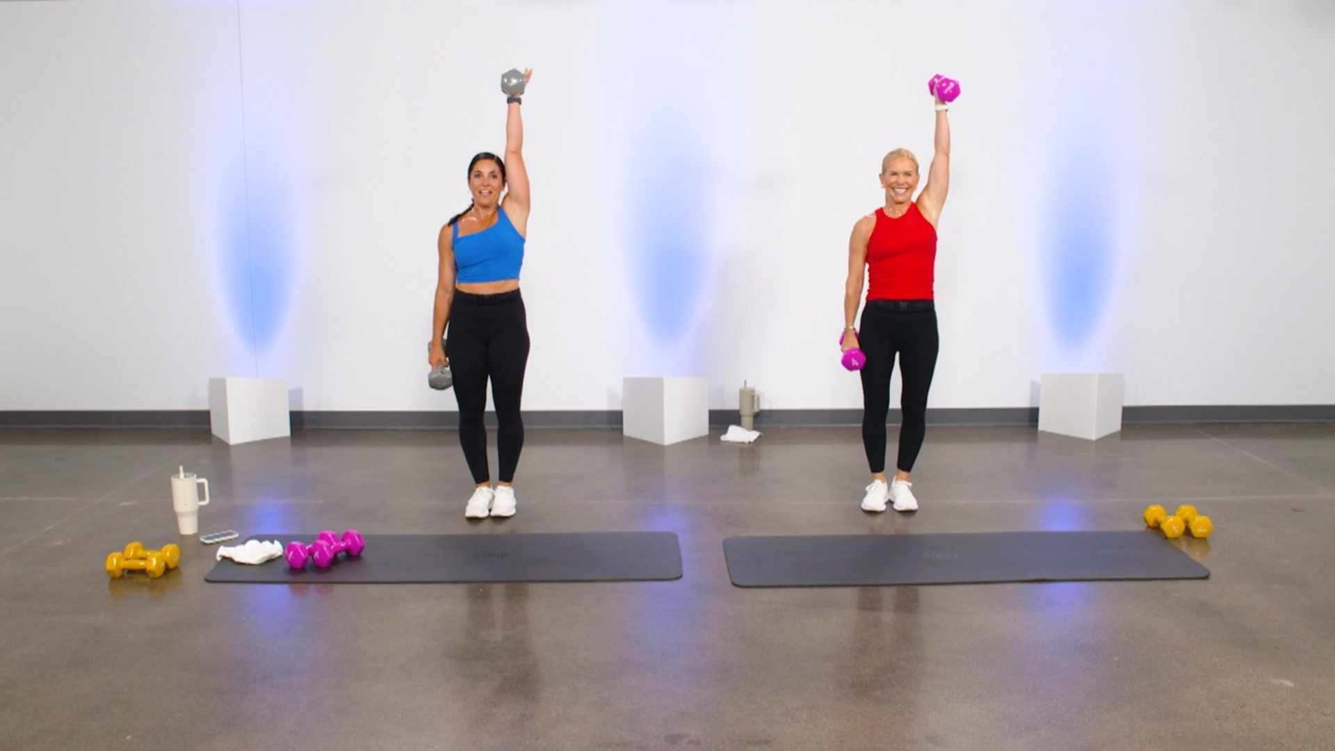 Two women doing single arm dumbbell presses