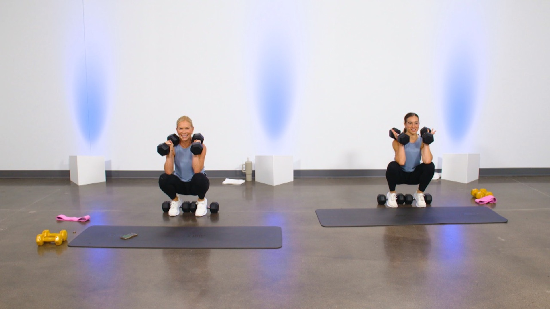 Two women doing dumbbell squats