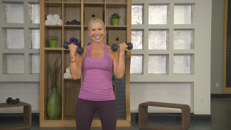 Woman in a purple tank top working out with dumbbells