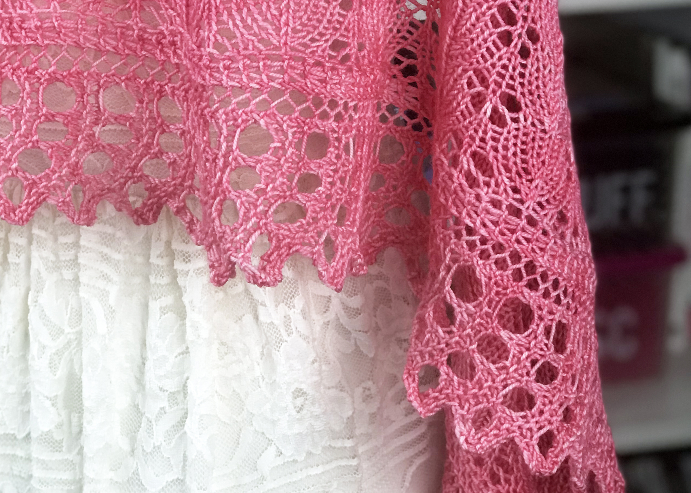 a close up of a completed pink shawl using double yarn over stitch