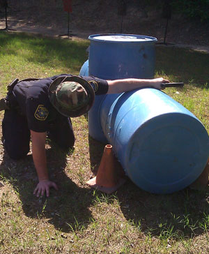 Image of a student shooting behind a low cover obstacle