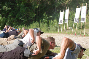 Students practice shooting while on their stomachs at targets
