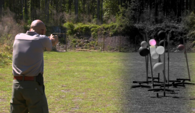 Man aiming at balloons outside